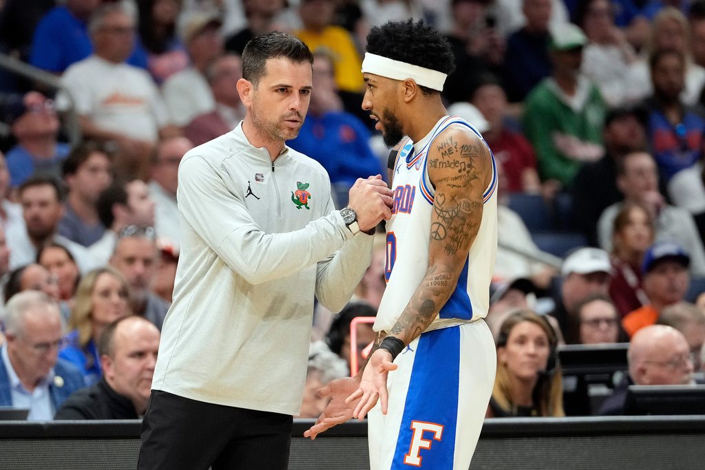 Florida head coach Todd Golden talks to guard Boogie Fland (0) during the second half in the second round of the NCAA college basketball tournament against Iowa Sunday, March 22, 2026, in Tampa, Fla. (AP Photo/Chris O'Meara)