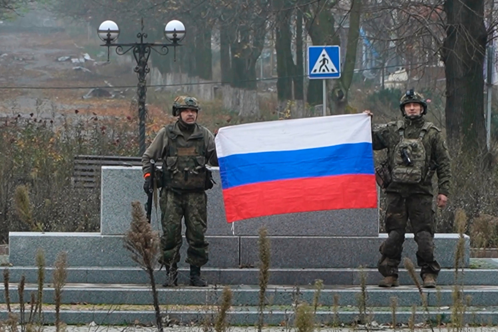 In this image made from video provided by Russian Defense Ministry Press Service on Tuesday, Dec. 2, 2025, Russian soldiers hold a Russian national flag in Pokrovsk, a city in the Donetsk region, Ukraine. (Russian Defense Ministry Press Service via AP)