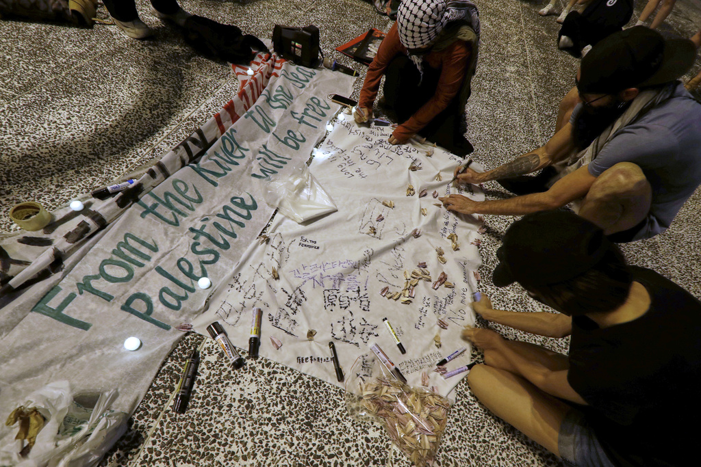 Pro-Palestinian protesters sign and make paper cranes during a candlelight vigil in support of Palestinians, in Taipei, Taiwan, Tuesday, Oct. 7, 2025. (AP Photo/Chiang Ying-ying)