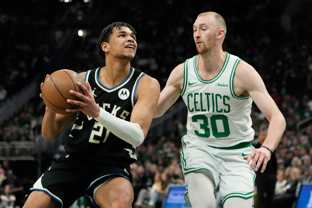 Milwaukee Bucks' Ousmane Dieng, left, drives to the basket against Boston Celtics' Sam Hauser (30) during the first half of an NBA basketball game Friday, April 3, 2026, in Milwaukee. (AP Photo/Aaron Gash)
