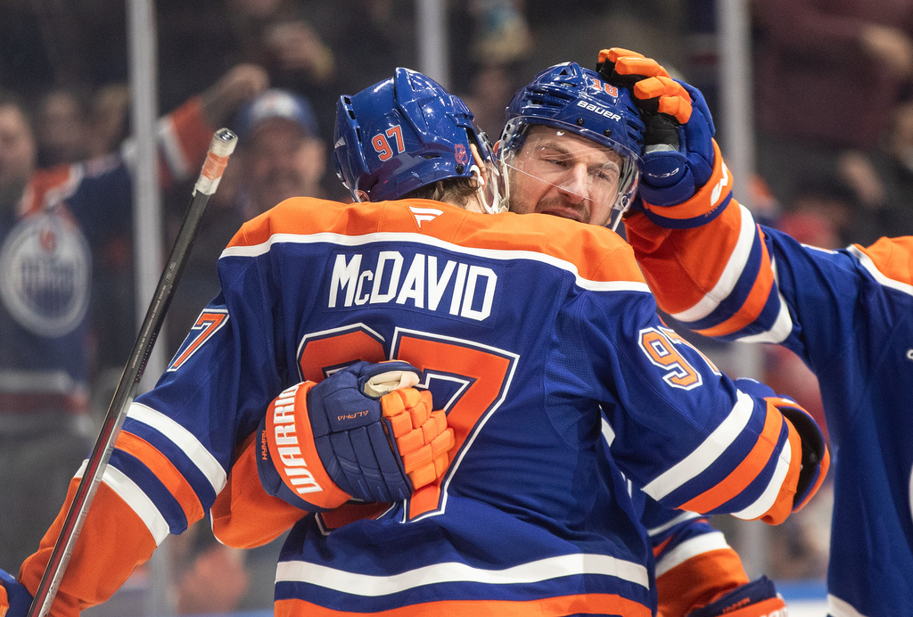 Edmonton Oilers' Connor McDavid (97) and Zach Hyman (18) celebrate a goal against the Detroit Red Wings during second period NHL action, in Edmonton on Thursday, Dec. 11, 2025. (Jason Franson/The Canadian Press via AP)