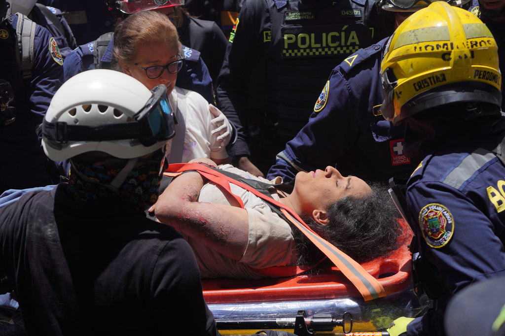 Rescue workers carry Diana Troncoso after pulling her from the rubble the day after an earthquake struck Cali, Colombia, Tuesday, Aug. 11, 2026. (AP Photo/Ivan Valencia) CORRECTION: Changes city to Cali, not Pereira.