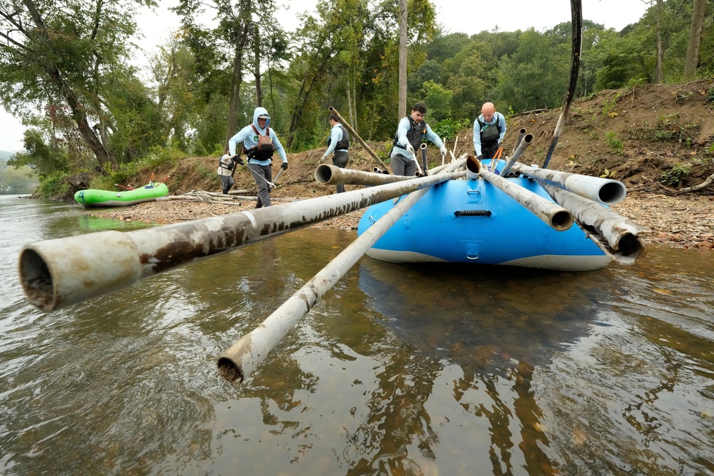 Members of the MountainTrue cleanup crew remove PVC pipes from the French Broad River on Wednesday, Sept. 17, 2025, in Asheville, N.C. (AP Photo/Chris Carlson)