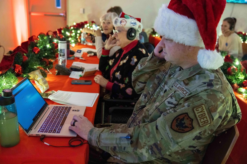 Volunteers take phone calls from children asking where Santa is and when he will deliver presents to their house, during the annual NORAD Tracks Santa Operation, at the North American Aerospace Defense Command, or NORAD, at Peterson Air Force Base, in Colorado Springs, Colo., on Tuesday, Dec. 24, 2024. (Thomas Paul/North American Aerospace Defense Command. via AP)