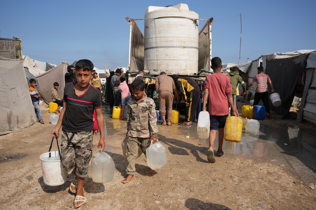 Displaced Palestinians gather to collect water from a truck at a makeshift tent camp in Khan Younis, southern Gaza Strip, Thursday, April 30, 2026. (AP Photo/Abdel Kareem Hana)