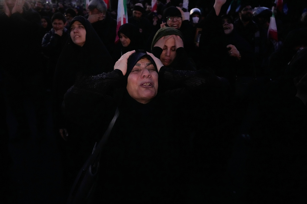 Government supporters mourn in a gathering after state TV officially announced the death of Iranian Supreme Leader Ayatollah Ali Khamenei, in Tehran, Iran, Sunday, March 1, 2026. (AP Photo/Vahid Salemi)