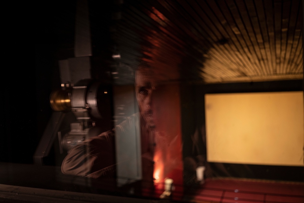 FILE - Rahmatullah Ezati looks out to the theatre from the projection room of the Ariana Cinema in Kabul, Afghanistan, Nov. 8, 2021, before the cinema was demolished in December 2025 by Taliban authorities to make way for a new shopping center. (AP Photo/Bram Janssen, File)
