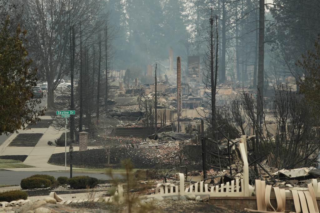 Structures along W. Tiffany Ave. are burned to the ground after a wildfire, Sunday, Aug. 2, 2026, in Spokane, Wash. (AP Photo/Young Kwak)
