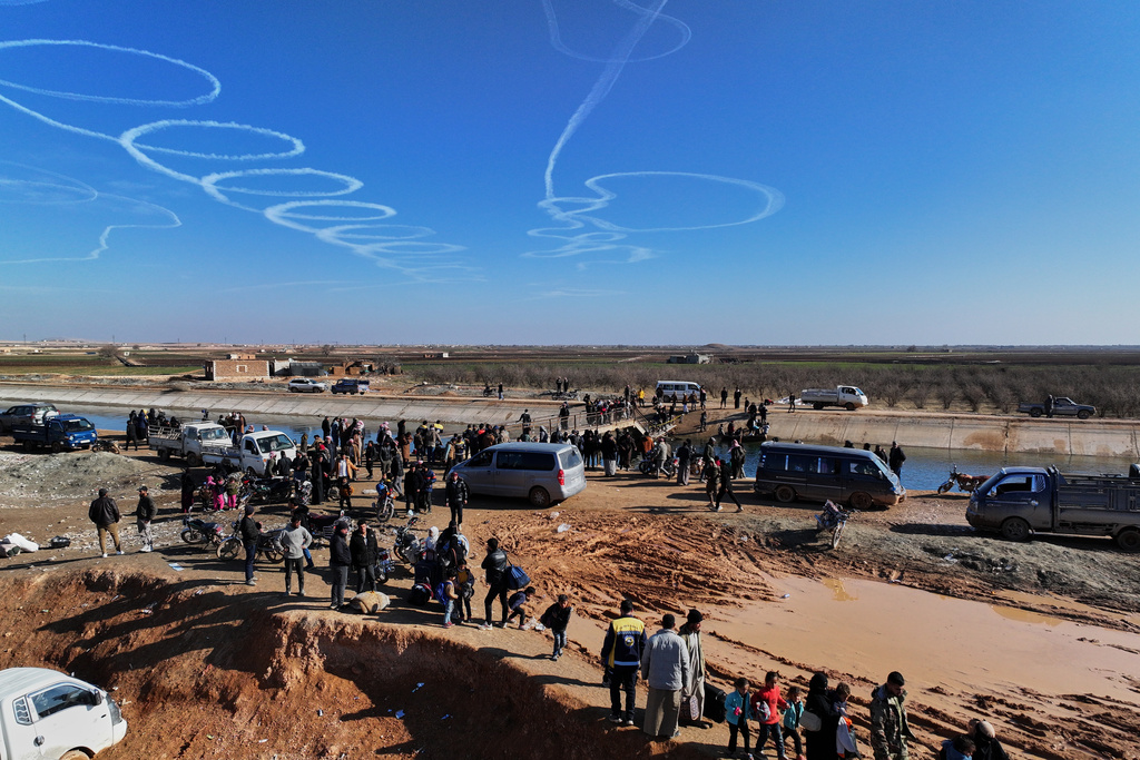 FILE - Displaced Syrians gather near a river crossing close to the village of Rasm al-Harmil al-Imam in the eastern Aleppo countryside, near the front line with the Kurdish-led Syrian Democratic Forces, in Deir Hafer, Syria, Friday, Jan. 16, 2026. Aerial pattern from unknown source. (AP Photo/Ghaith Alsayed)