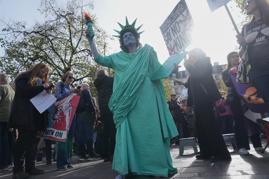 A woman dressed like the Statue of Liberty attends a protest against U.S. President Donald Trump, in Paris, Saturday, Oct. 18, 2025. (AP Photo/Thibault Camus)