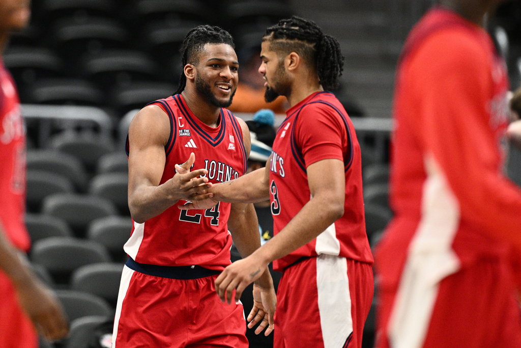 St. John's forward Zuby Ejiofor (24) reacts with forward Bryce Hopkins, right, during the second half of an NCAA college basketball game against Georgetown, Wednesday, Dec. 31, 2025, in Washington. (AP Photo/Nick Wass)