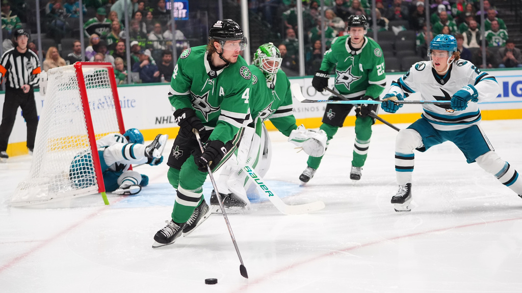 Dallas Stars defenseman Miro Heiskanen (4) takes control of the puck as San Jose Sharks center Will Smith (2) skates up during the second period of an NHL hockey game Friday, Dec. 5, 2025, in Dallas. (AP Photo/LM Otero)