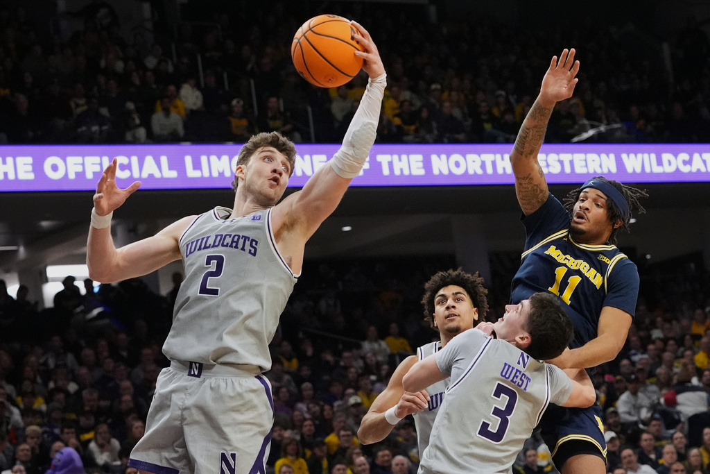 Northwestern forward Nick Martinelli (2) rebounds a ball against Michigan guard Roddy Gayle Jr. (11) during the first half of an NCAA college basketball game, in Evanston, Ill., Wednesday, Feb. 11, 2026. (AP Photo/Nam Y. Huh)
