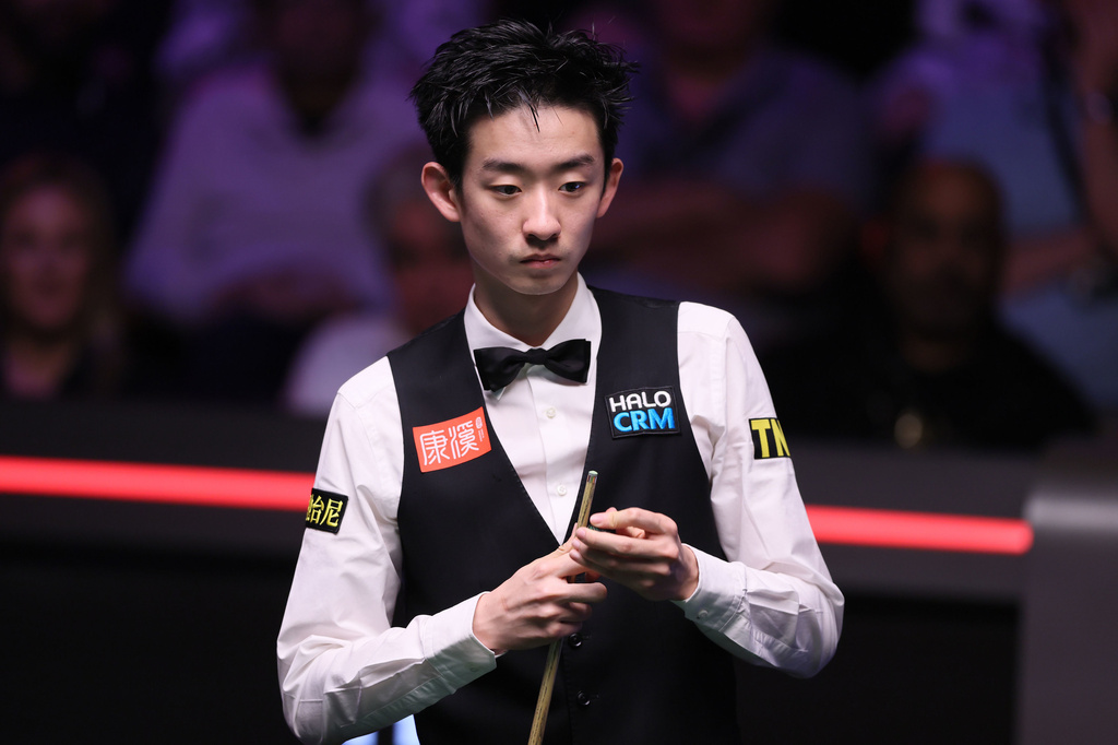 Wu Yize looks over the table during his match against Mark Allen on day fifteen of the World Snooker Championship 2026, in Sheffield, England, Saturday May 2, 2026. (Richard Sellers/PA via AP)