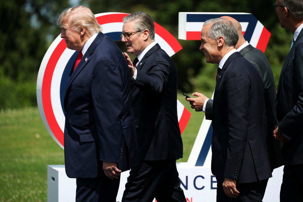U.S. President Donald Trump, left, British Prime Minister Keir Starmer, center, and Canada's Prime Minister Mark Carney arrive for a group photo at the G7 summit in Evian-les-Bains, France, Tuesday June 16, 2026. (Isabel Infantes/Pool Photo via AP)