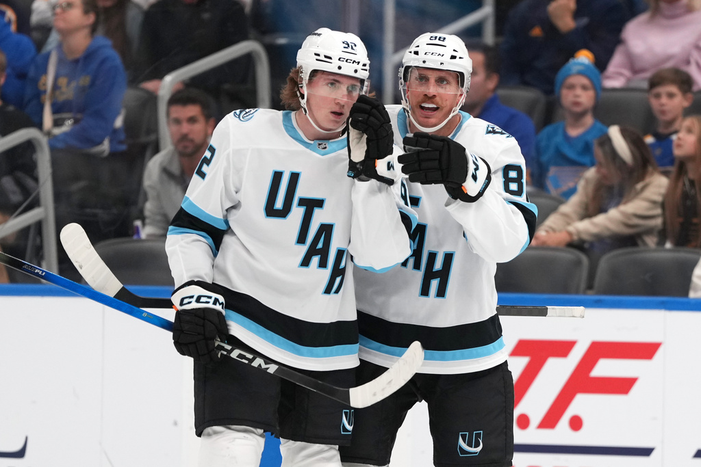 Utah Mammoth's Logan Cooley, left, is congratulated by Nate Schmidt after scoring during the first period of an NHL hockey game against the St. Louis Blues Thursday, Oct. 23, 2025, in St. Louis. (AP Photo/Jeff Roberson)