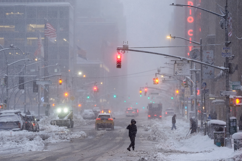 A pedestrian crosses Sixth Avenue during a snow storm, Monday, Feb. 23, 2026, in New York. (AP Photo/Seth Wenig)