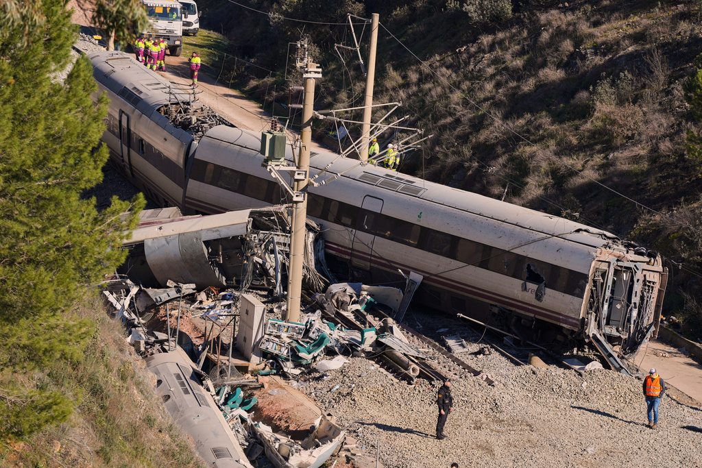 Guardia Civil officers collect evidence next to the wreckage of train cars involved in a collision in Adamuz, southern Spain, Tuesday, Jan. 20, 2026. (AP Photo/Manu Fernandez)