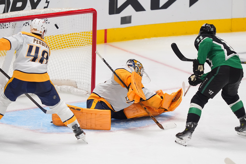 Dallas Stars right wing Nathan Bastian (11) scores a goal against Nashville Predators goaltender Juuse Saros (74) and defenseman Nick Perbix (48) during the third period of an NHL hockey game Saturday, Feb. 28, 2026, in Dallas. (AP Photo/LM Otero)