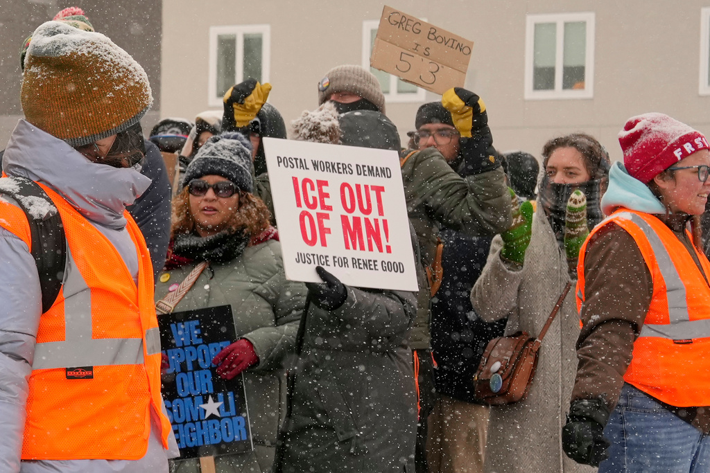 People march and gather near the post office during a protest, Sunday, Jan. 18, 2026, in Minneapolis. (AP Photo/Yuki Iwamura)