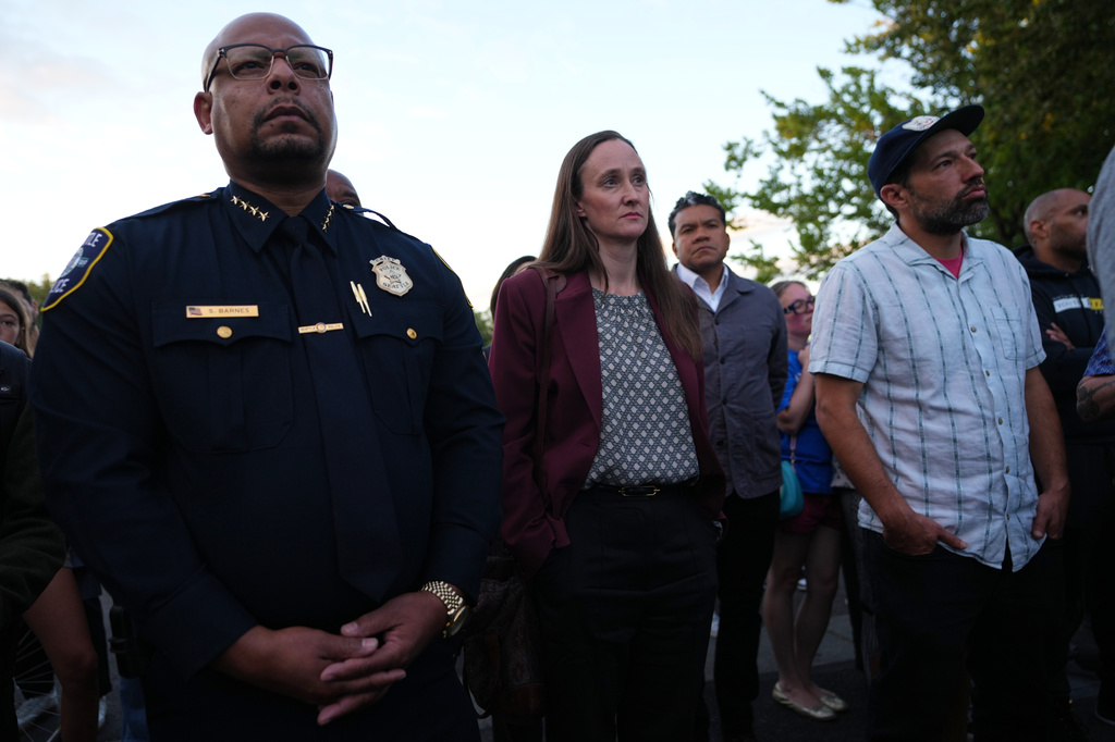 Seattle Mayor Katie Wilson, center, and Seattle Police Chief Shon Barnes, left, attend the vigil for victims the day after a shooting at Seattle Center during the Bite of Seattle food festival, Monday, July 27, 2026, in Seattle. (AP Photo/Lindsey Wasson)