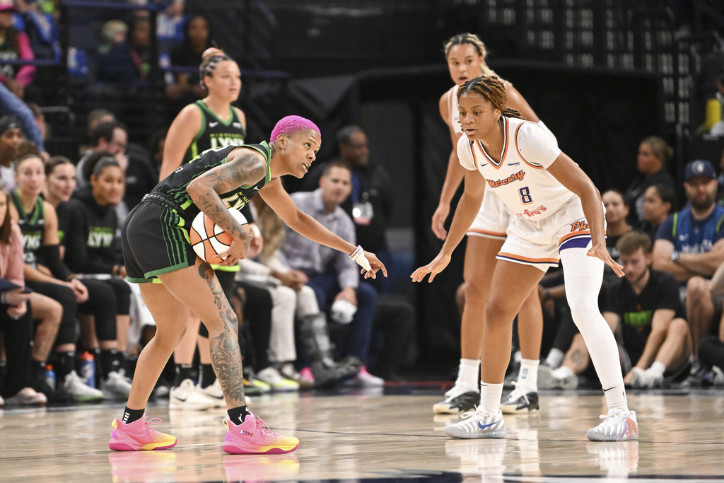 Minnesota Lynx guard Courtney Williams, left, directs traffic as Phoenix Mercury guard Monique Akoa Makani (8) defends during the first half of Game 1 of a WNBA basketball playoff semifinals series Sunday, Sept. 21, 2025, in Minneapolis. (AP Photo/Craig Lassig)