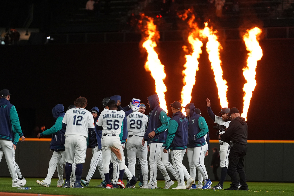 Seattle Mariners' Cal Raleigh (29) celebrates his game-winning single against the New York Yankees in the ninth inning with teammates after a baseball game, Monday, March 30, 2026, in Seattle. (AP Photo/Lindsey Wasson)