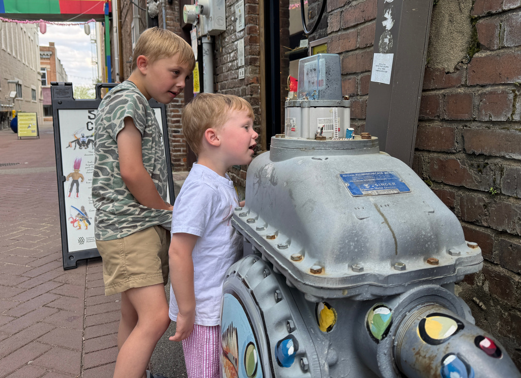 Two boys stare at figurines at the Hattiesburg Pocket Museum, in Hattiesburg, Miss., on Wednesday, March 25, 2026. (AP Photo/Sophie Bates)