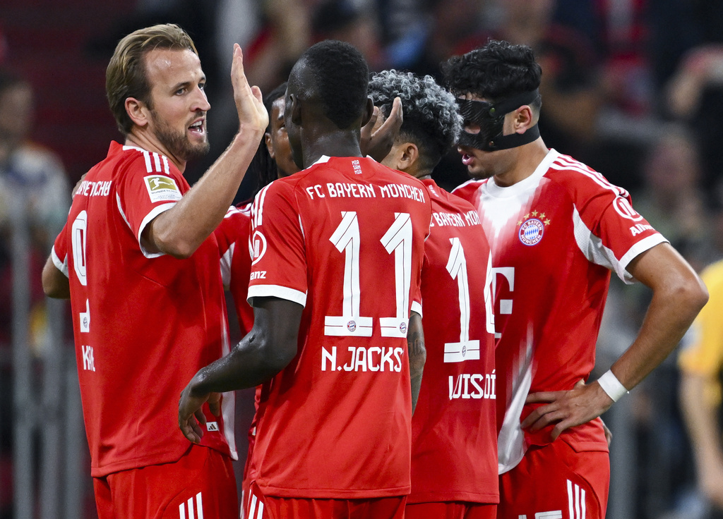 Munich's scorer Harry Kane, left, and his teammates celebrate their side's fifth goal goal during the German Bundesliga soccer match between FC Bayern Munich and Hamburger SV in Munich, Germany, Saturday, Sept. 13, 2025. (Sven Hoppe/dpa via AP)