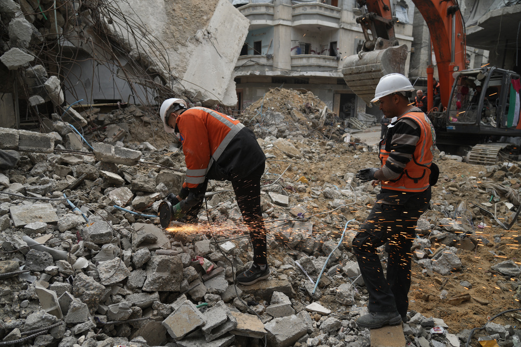 Gaza's civil defense teams work to recover the remains of members of the Abu Nada family, who remain trapped beneath the rubble of their four-story house after it was destroyed by an Israeli airstrike in December 2023, in Gaza City, Monday, Feb. 9, 2026. (AP Photo/Jehad Alshrafi)