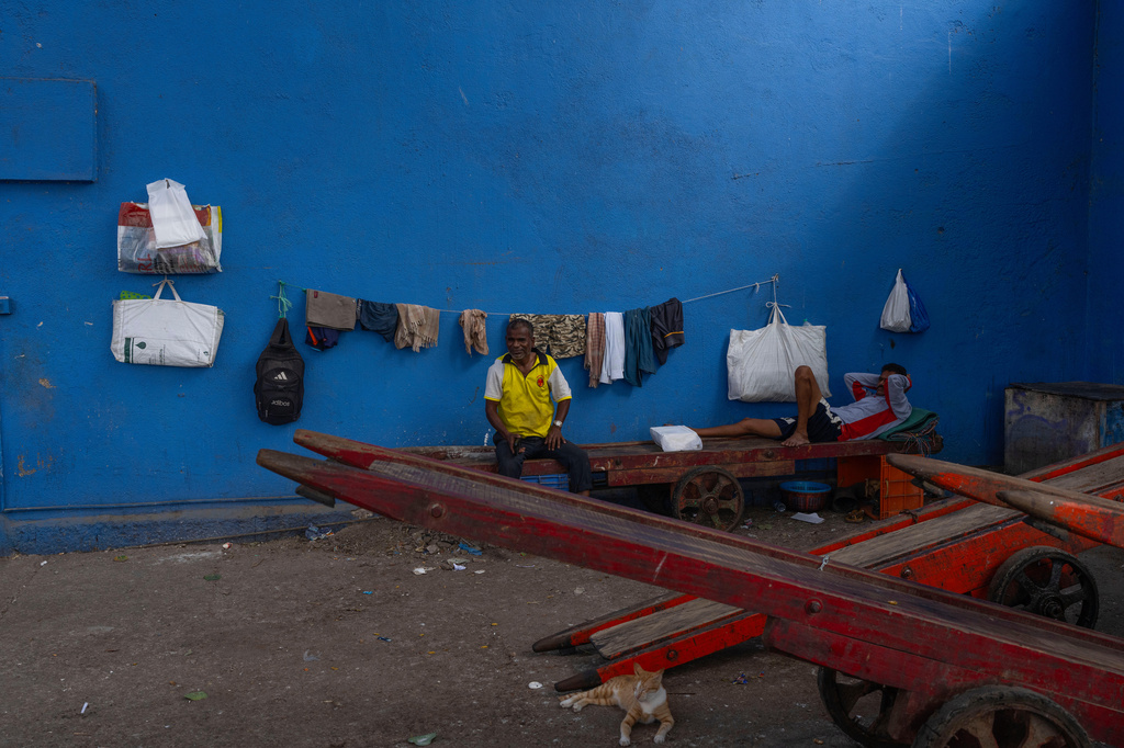 Deckhands rest at Sassoon dock in Mumbai, India, Wednesday, April 8, 2026. (AP Photo/Rafiq Maqbool)
