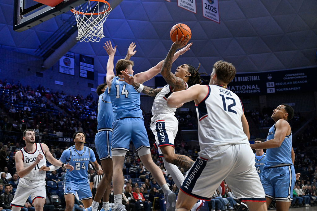 UConn guard Solo Ball, center goes up for a basket against Columbia forward Mason Ritter in the first half of an NCAA college basketball game, Monday, Nov. 10, 2025, in Storrs, Conn. (AP Photo/Jessica Hill)