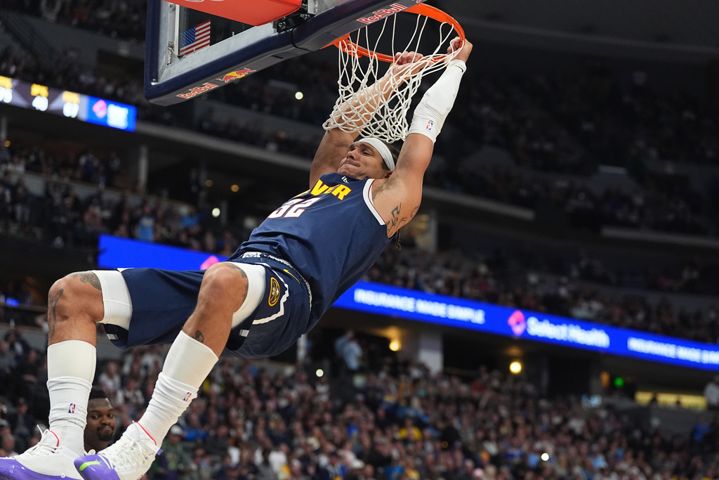 Denver Nuggets forward Aaron Gordon hangs on the rim after dunking the ball for a basket against the New Orleans Pelicans in the first half of an NBA basketball game Wednesday, Oct. 29, 2025, in Denver. (AP Photo/David Zalubowski)
