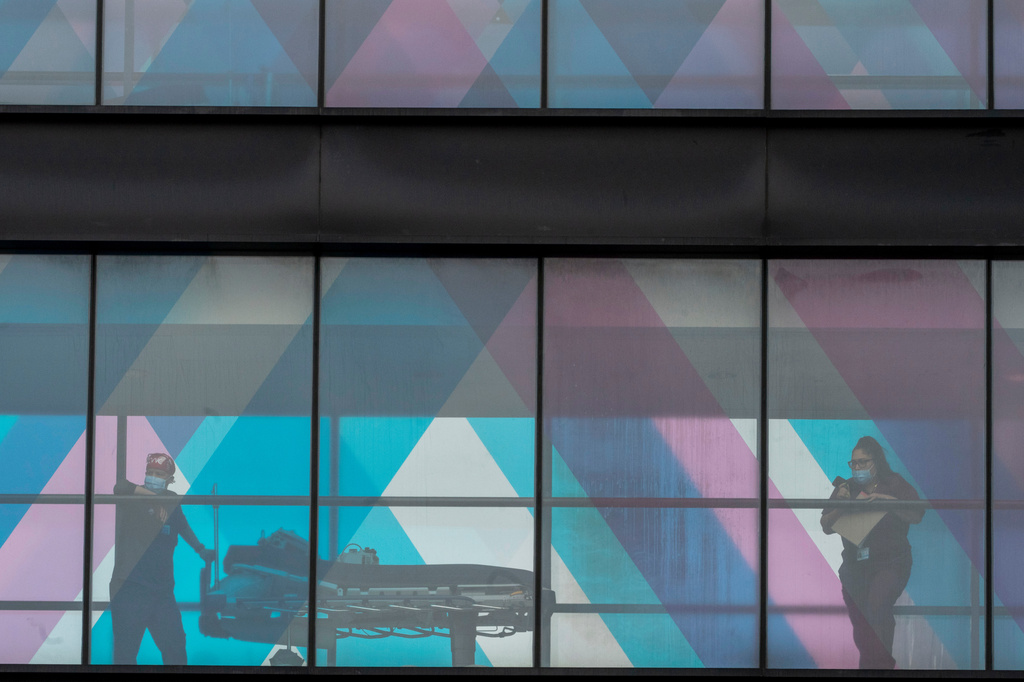 FILE - Health care workers look out a window at NY Presbyterian and Mount Sinai, March 16, 2021, in New York. (AP Photo/Mary Altaffer, File)