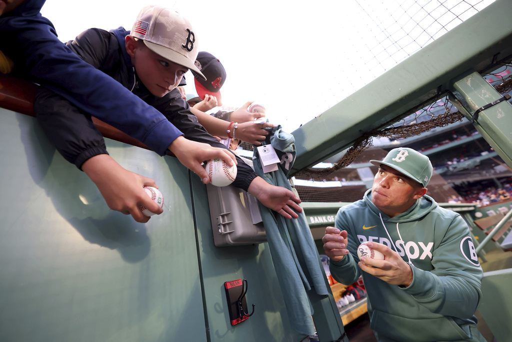 Boston Red Sox third baseman Nate Eaton, right, asks for a pen to sign a ball for a fan before a baseball game against the Pittsburgh Pirates, Friday, Aug. 29, 2025, in Boston. (AP Photo/Mark Stockwell)