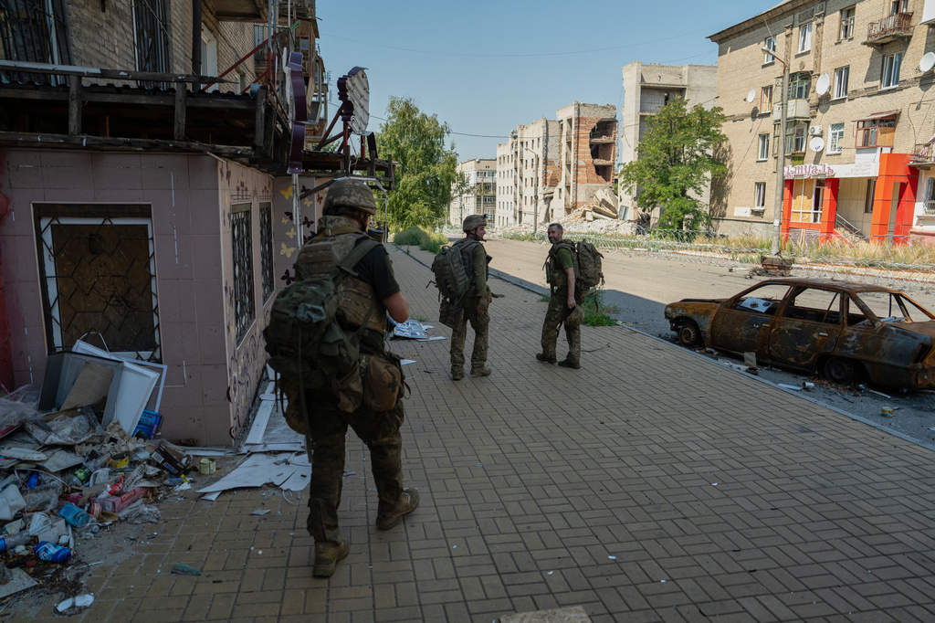 In this photo provided by Ukraine's 93rd Kholodnyi Yar Separate Mechanized Brigade press service and taken Monday, Aug. 10, 2026, Ukrainian soldiers walk along the street in the frontline town of Druzhkivka, Donetsk region, Ukraine. (Iryna Rybakova/Ukraine's 93rd Mechanized Brigade via AP))