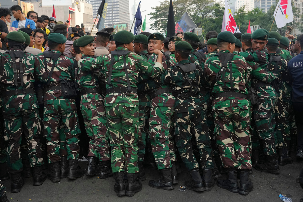 Indonesian soldiers block student protesters during a rally against a fuel price hike, government inefficient spendings, and military involvement in civilian affairs in Jakarta, Indonesia, Friday, June 12, 2026. (AP Photo/Tatan Syuflana)