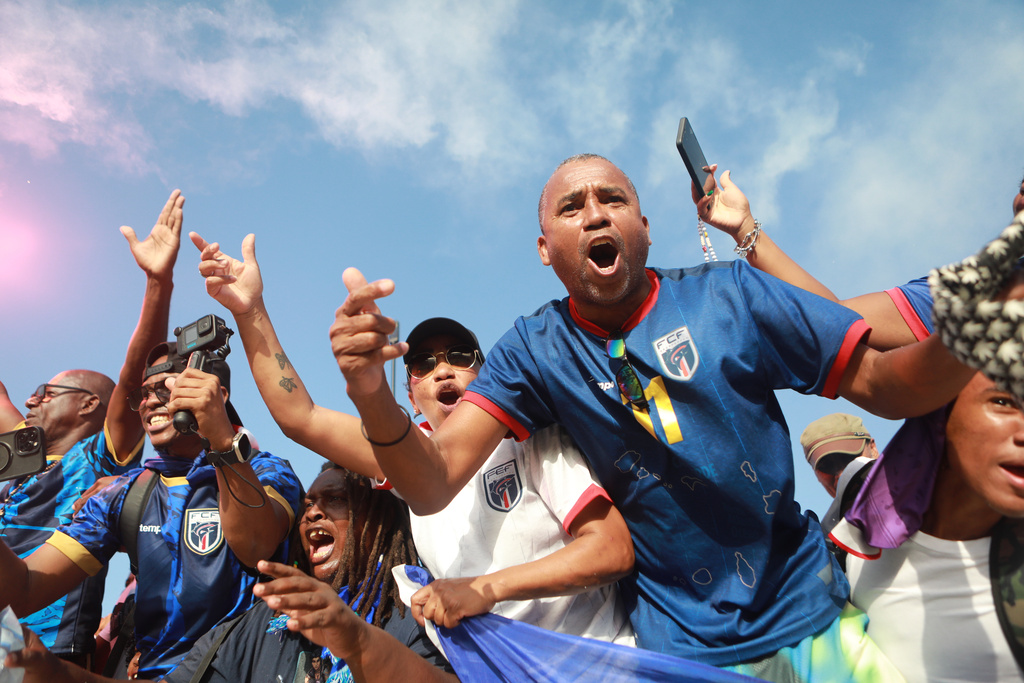 Fans celebrate in the stands after Cape Verde defeated Eswatini in a World Cup qualifying soccer match at Estádio Nacional in Praia, Cape Verde, Monday, Oct. 13, 2025, to clinch their qualification for the 2026 World Cup. (AP Photo/Cristiano Barbosa)