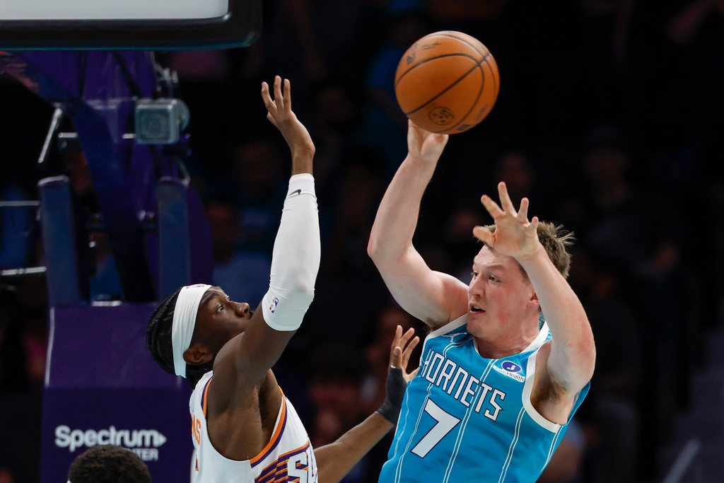 Charlotte Hornets guard Kon Knueppel (7) passes against Phoenix Suns center Mark Williams during the first half of an NBA basketball game in Charlotte, N.C., Thursday, April 2, 2026. (AP Photo/Nell Redmond)