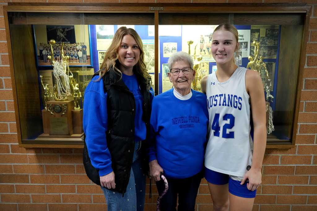 Marie Breon, center, poses for a photo with her granddaughter, Andrea Vanderhoff, left, and great-granddaughter, Madelyn Vanderhoff, right, after a Newell-Fonda high school girls basketball game against Storm Lake, Jan. 6, 2026, in Newell, Iowa. (AP Photo/Charlie Neibergall)