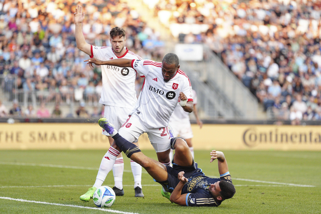 Toronto FC's Deybi Flores (20) and Philadelphia Union's Tai Baribo, bottom, battle for the ball during the first half of an MLS soccer match, Saturday, Aug. 9, 2025, in Chester, Pa. (AP Photo/Derik Hamilton)