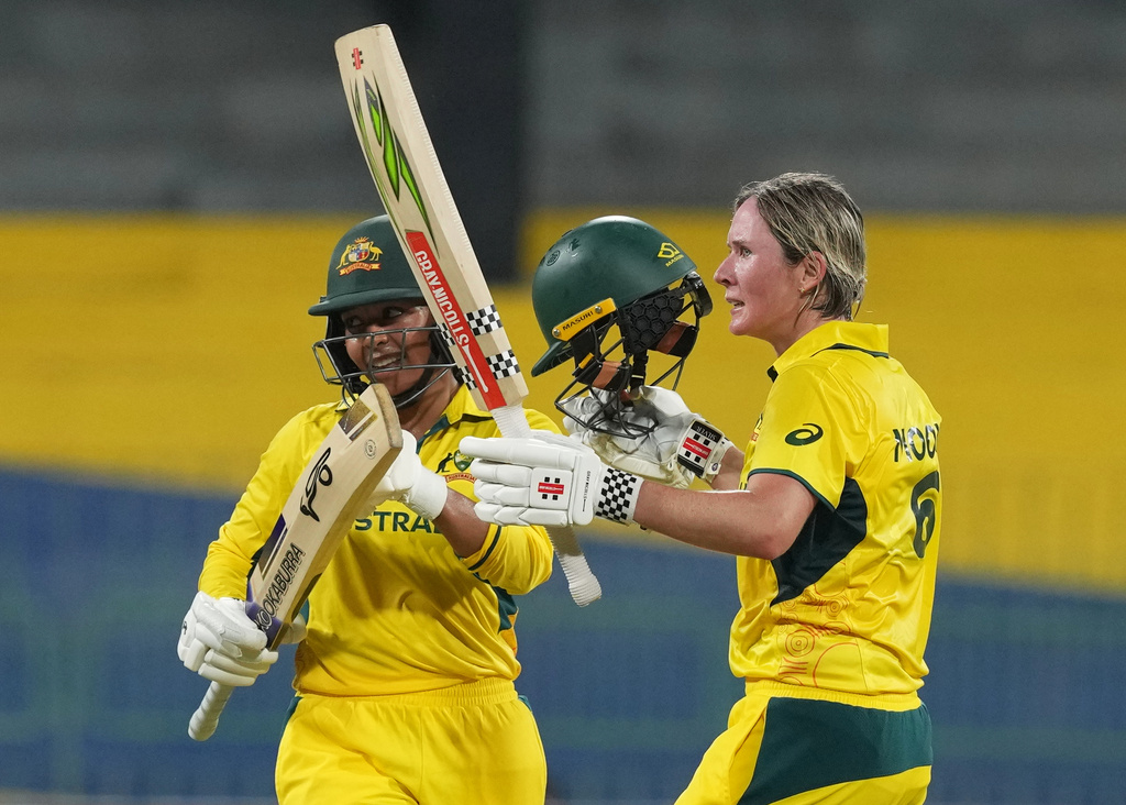 Australia's Beth Mooney, right, celebrates her as Alana King watches during the ICC Women's Cricket World Cup match between Australia and Pakistan at Premadasa Stadium in Colombo, Sri Lanka, Wednesday, Oct, 8, 2025. (AP Photo/Eranga Jayawardena)