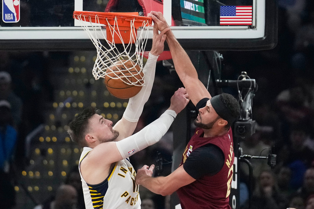 Cleveland Cavaliers forward Larry Nance Jr. (22) dunks ober Indiana Pacers center Micah Potter, left, in the first half of an NBA basketball game in Cleveland, Sunday, April 5, 2026. (AP Photo/Sue Ogrocki)