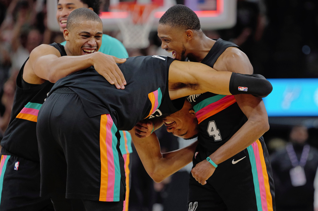 San Antonio Spurs players Victor Wembanyama, center, De'Aaron Fox (4) and Keldon Johnson celebrate their win after an NBA basketball game against the Los Angeles Clippers, Friday, March 6, 2026, in San Antonio. (AP Photo/Darren Abate)