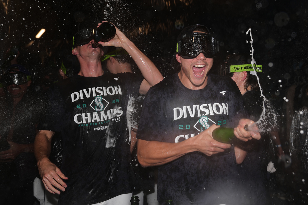Seattle Mariners starting pitchers Bryan Woo, right, and Emerson Hancock celebrate after the team's win against the Colorado Rockies to clinch the American League West Division, Wednesday, Sept. 24, 2025, in Seattle. (AP Photo/Ryan Sun)