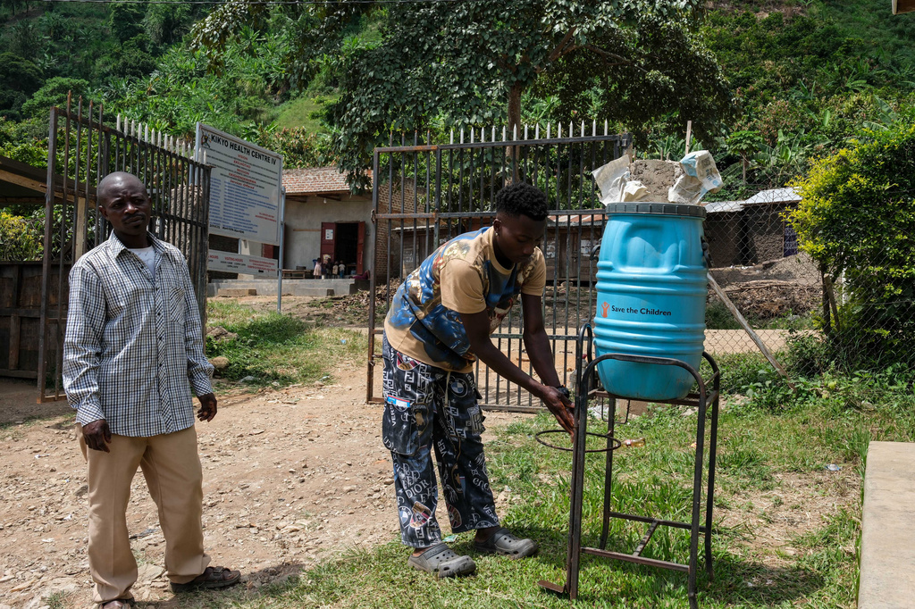People wash their hands before entering Kikyo Health Centre IV in Kikyo Trading village, Bundibugyo District, Wednesday, June 3, 2026. (AP Photo/Hajarah Nalwadda)