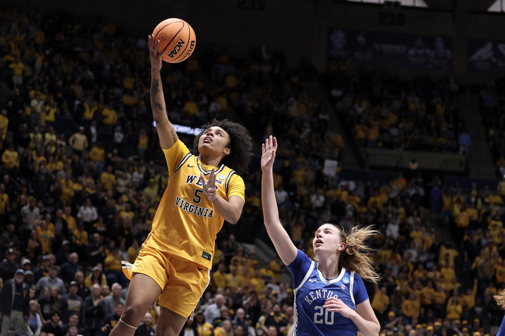 West Virginia guard Sydney Shaw (5) goes up to shoot while defended by Kentucky forward Kaelyn Carroll (20) in the first half in the second round of the NCAA college basketball tournament, Monday, March 23, 2026, in Morgantown, W.Va. (AP Photo/Kathleen Batten)