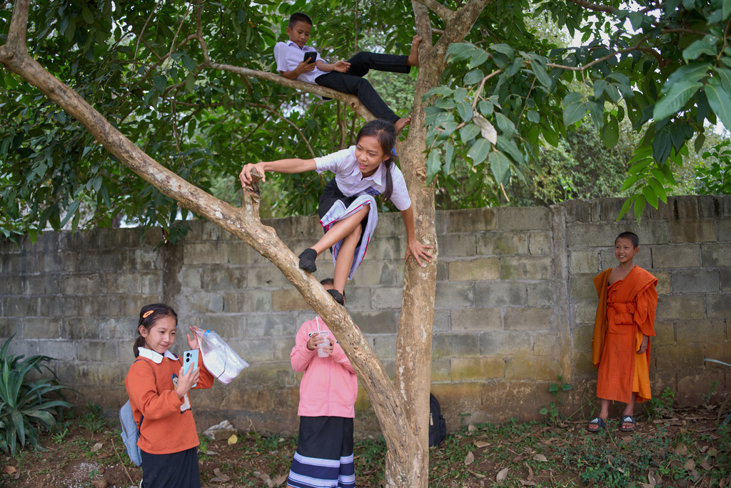Students from an elementary school, including a novice Buddhist monk, play after class in Luang Prabang, Laos, Tuesday, Nov. 4, 2025. (AP Photo/Eugene Hoshiko)