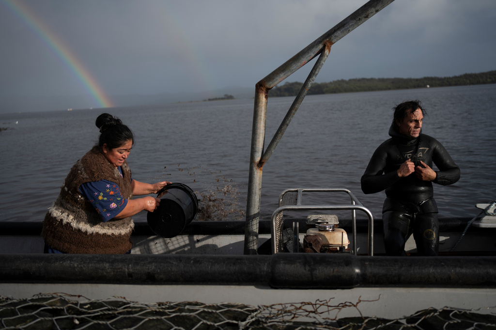 Yesica Fabiana Levi&ntilde;anco, left, and her partner, Paulo Vera Perez, prepare for a fishing journey in Repollal, in the Guaitecas Archipelago, Chile, Wednesday, May 21, 2025. (AP Photo/Adriana Thomasa)