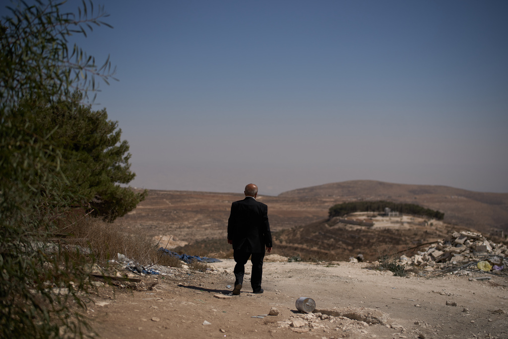 Suheil Nazzal, a parishioner at the local Catholic Church, looks at a hill covered with olive trees belonging to his family in the West Bank village of Taybeh, Sept. 28, 2025, which, according to him, they cannot access due to the presence of Israeli settlers. (AP Photo/Leo Correa)